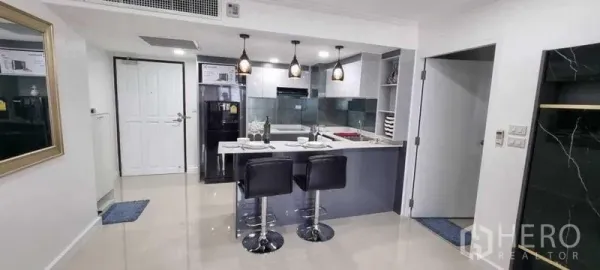 公寓 出租在Khlong Toei, Bangkok - 开放式厨房设早餐岛台、吊灯与两张吧椅，设计简洁。