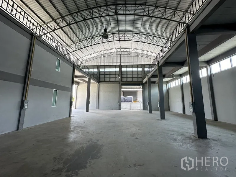 工厂 出租在Lam Luk Ka, Pathum Thani - 高挑仓库大厅，拱形钢结构屋顶，混凝土地面与高柱。