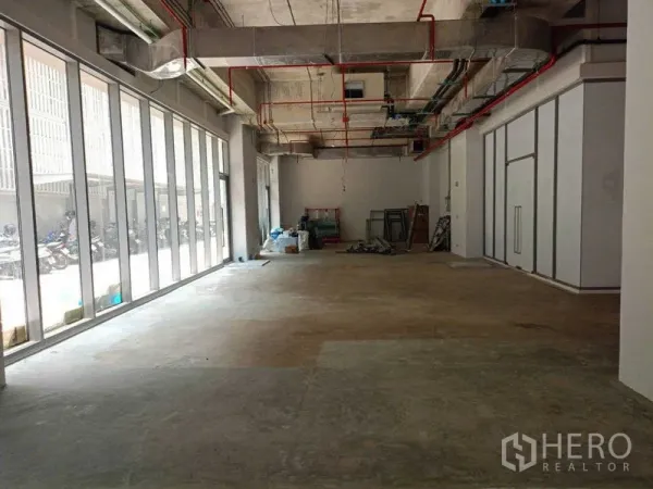 零售空间 出租在Watthana, Bangkok - 长条形室内与整面落地窗，原始水泥地，适合展厅或咖啡店