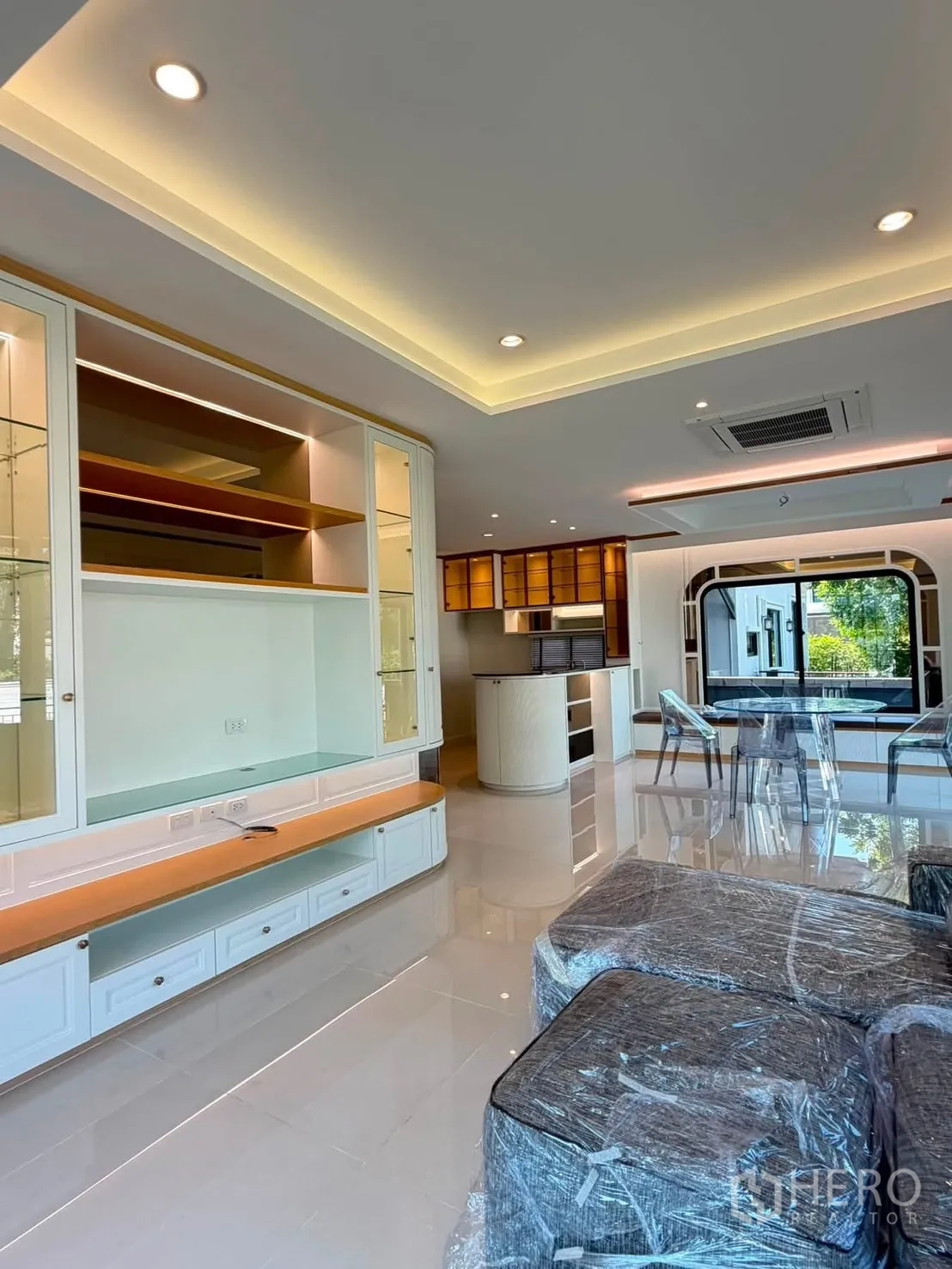 Detached House for rent or sale in Prawet, Bangkok - Spacious living room with built-in TV wall and cove lighting.