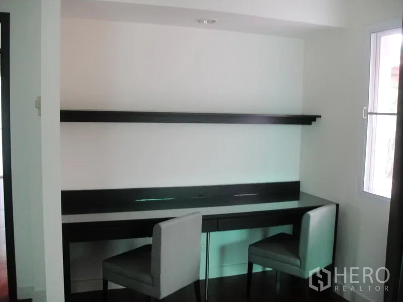 Detached House for rent in Wang Thonglang, Bangkok - Study corner with long built-in desk, shelving and two chairs by a window.