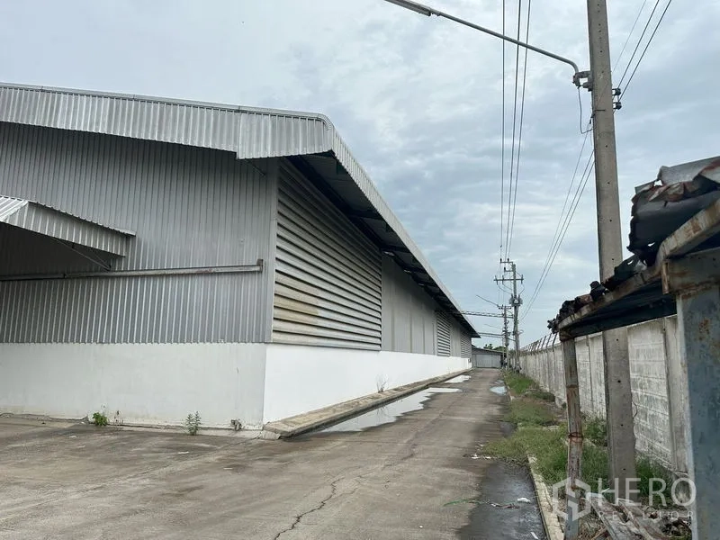 工厂 出租在Lat Lum Kaeo, Pathum Thani - 金属包板工厂外立面，服务通道、电线杆与围墙，位于巴吞他尼。