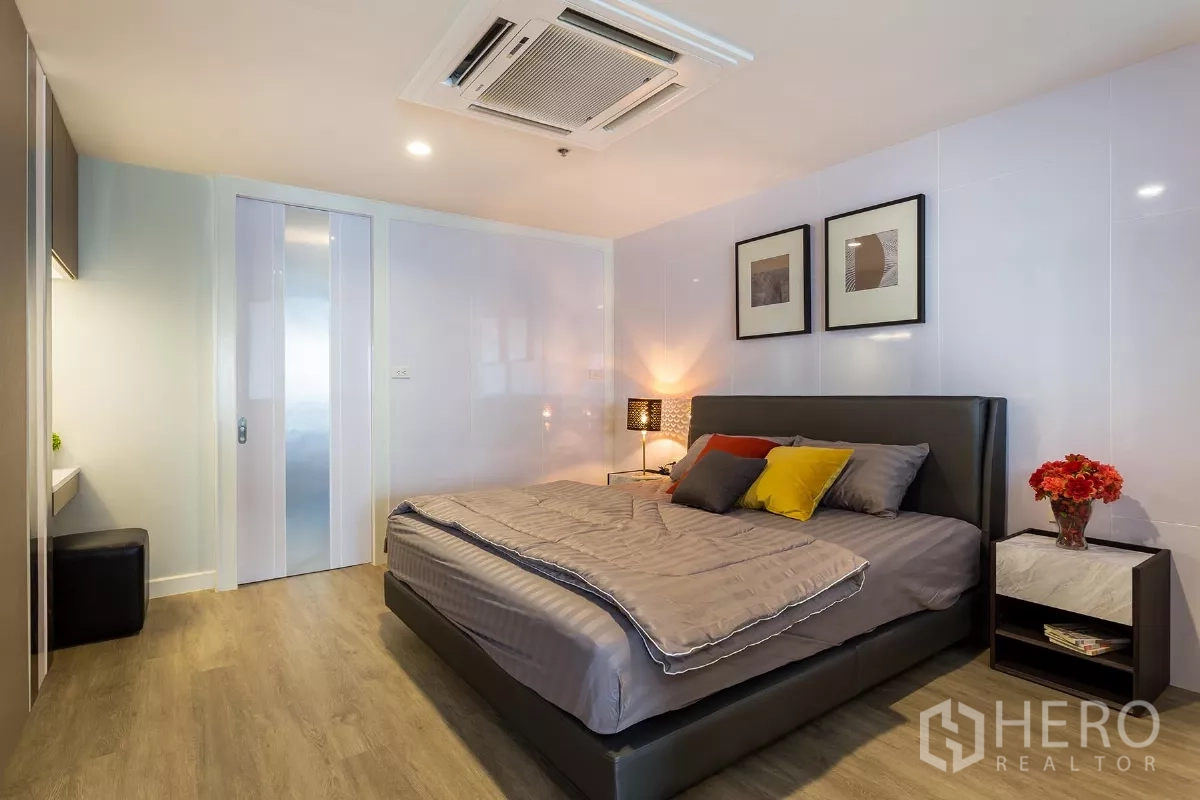 Condominium for rent or sale in Watthana, Bangkok - Primary bedroom with king bed, bedside lamps and warm ambient lighting.