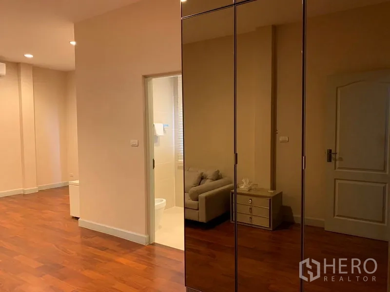 Detached House for rent or sale in Khan Na Yao, Bangkok - Master suite corridor with glossy wardrobes and doorway to ensuite bathroom.
