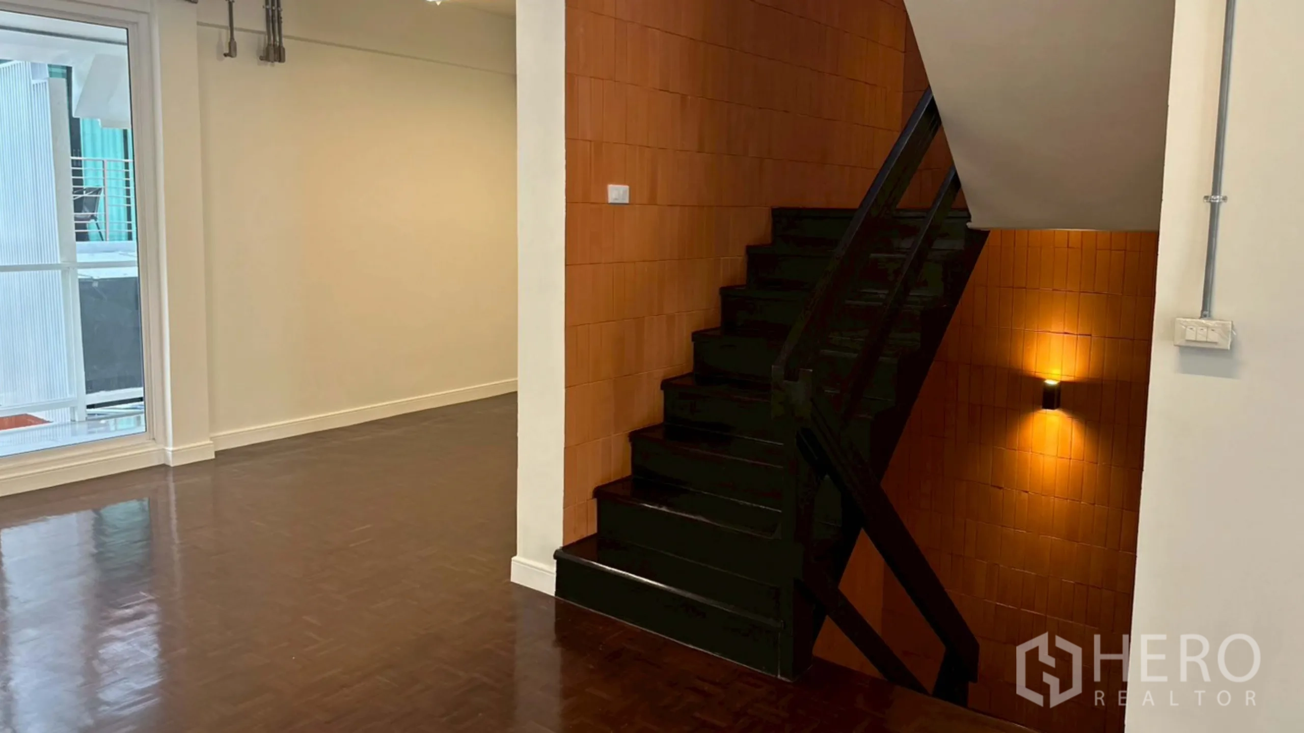 Home Office for rent in Watthana, Bangkok - Staircase corner with warm wall sconces and terracotta finish.