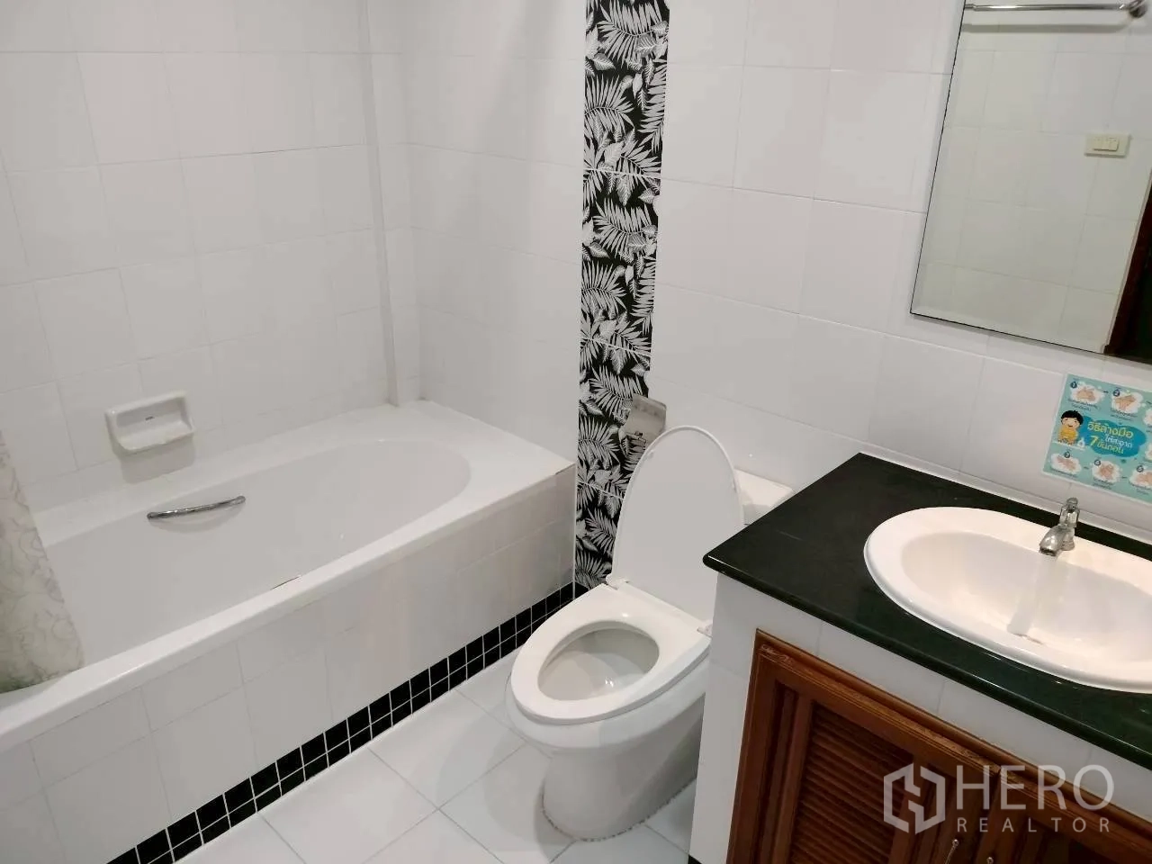 Home Office for rent in Watthana, Bangkok - Bathroom with bathtub, toilet, vanity, and decorative tile strip.