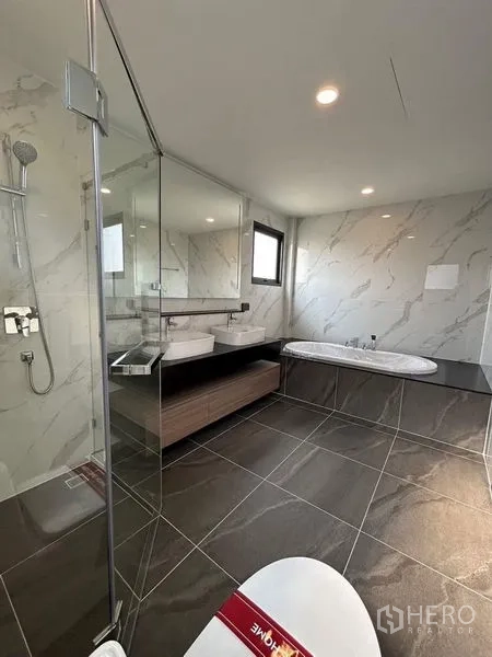 Detached House for rent - Luxury master bathroom with bathtub, glass shower, and marble-look walls.