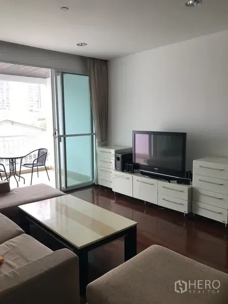 คอนโด ให้เช่าในKhlong Toei, Bangkok - ห้องนั่งเล่นพร้อมโซฟา ตู้ทีวี และประตูกระจกบานเลื่อนออกสู่ระเบียง