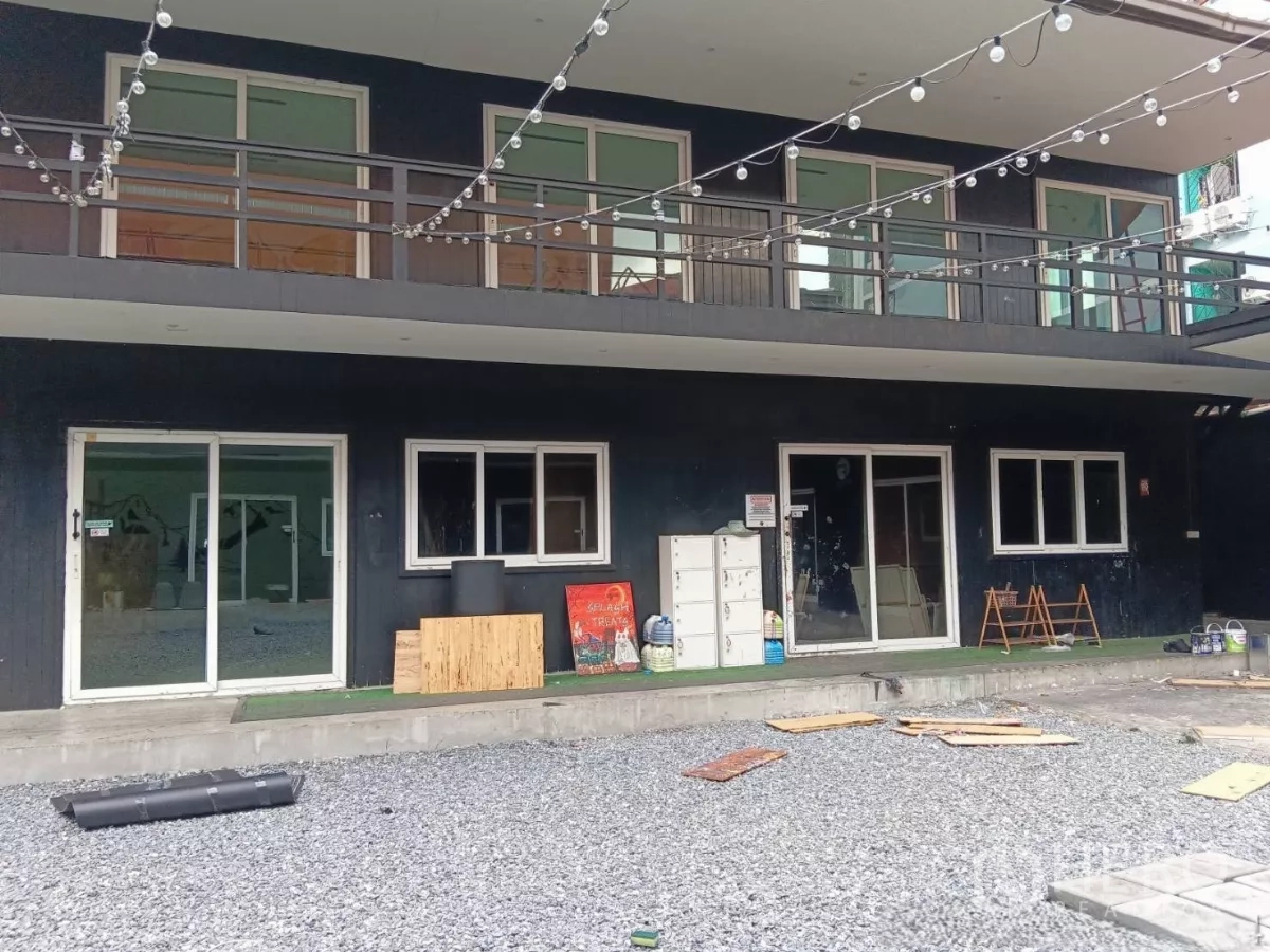 零售空间 出租在Huai Khwang, Bangkok - 一层店面近景，上层阳台与串灯装饰立面。