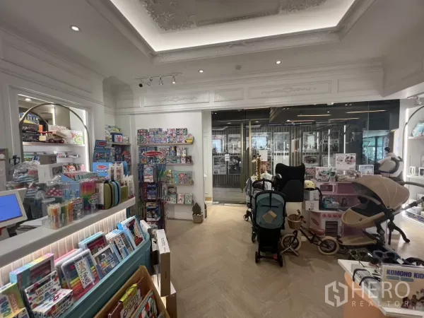 Retail Space for rent in Watthana, Bangkok - Front sales area with strollers, cashier counter and glass entrance under spotlights.