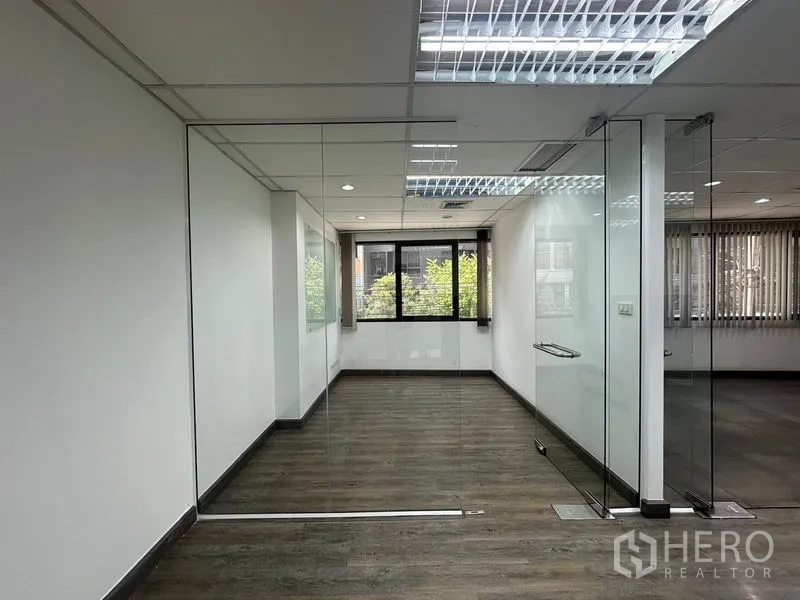 办公空间 出租在Khlong Toei, Bangkok - 玻璃墙会议室，单开门，可见窗外绿意