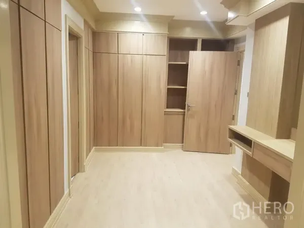 Apartment for rent in Khlong Toei, Bangkok - Built-in wood wardrobes and shelving in a bright corridor space