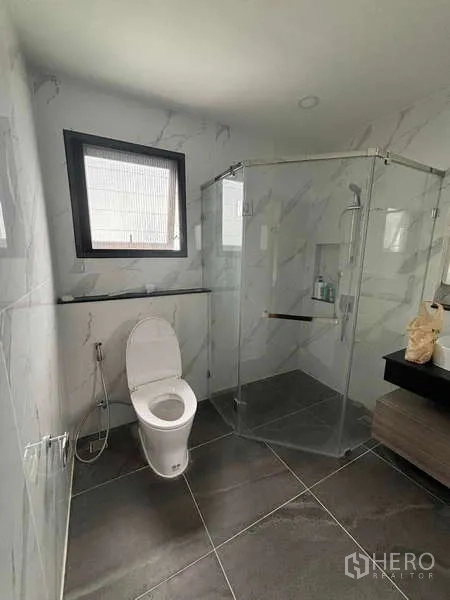 บ้าน ให้เช่าในMueang Nonthaburi, Nonthaburi - ห้องน้ำสว่างพร้อมตู้กระจกกั้นอาบน้ำ โถสุขภัณฑ์ และผนังลายหินอ่อน