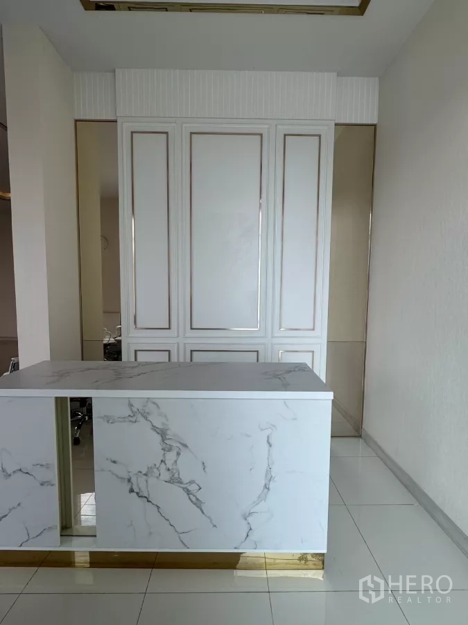 Factory for sale in Lam Luk Ka, Pathum Thani - Reception area featuring a marble-look counter with gold trim and paneled wall.