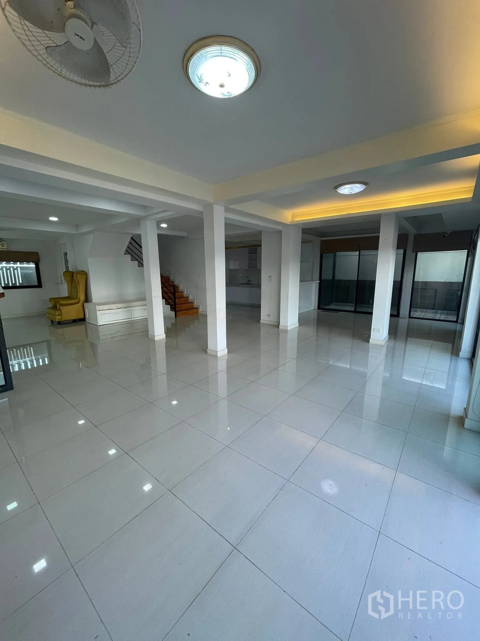 Detached House for rent or sale in Lam Luk Ka, Pathum Thani - Expansive open-plan living hall with pillars and shiny tiled floor.