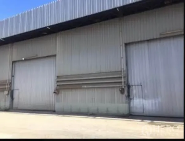 货栈 出租在Sai Mai, Bangkok - 金属板外立面的仓库正面，配有两扇大滑门与室外混凝土装卸区