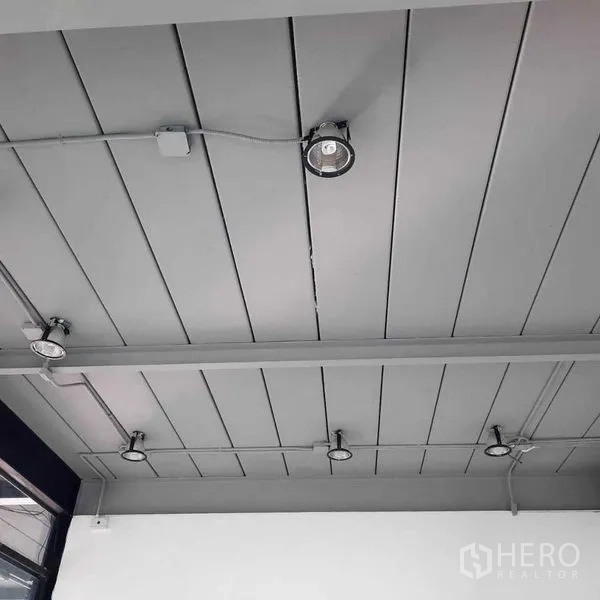 零售空间 出租在Lat Phrao, Bangkok - 灰色拼板天花特写，可见多盏圆形射灯与电管。
