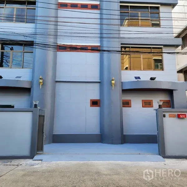 สำนักงาน ให้เช่าหรือขายในKhlong Toei, Bangkok - มุมใกล้ของทางเข้าด้านหน้า เสากลมสีเทาคู่ มีโคมไฟผนังและหน้าต่างขนาดใหญ่