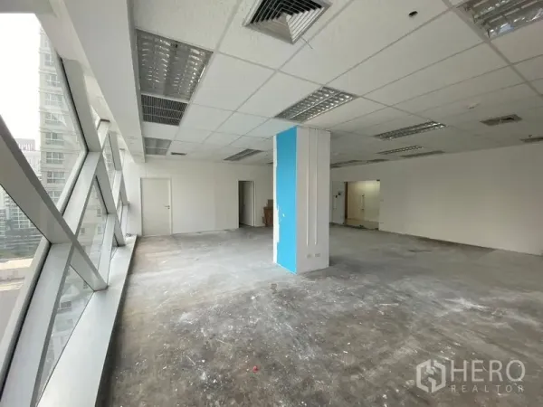 Office Space for rent in Phra Khanong, Bangkok - Unfurnished 105 sqm office floor with suspended ceiling lights, central AC vents, and a corner pillar.