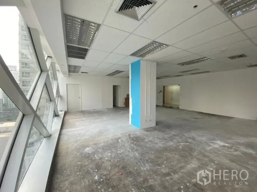 Office Space for rent in Phra Khanong, Bangkok - Unfurnished 105 sqm office floor with suspended ceiling lights, central AC vents, and a corner pillar.