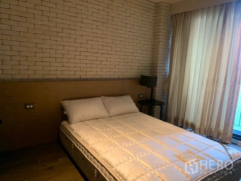 คอนโด ให้เช่าในWatthana, Bangkok - ห้องนอนอบอุ่น ผนังอิฐตกแต่ง ม่านโปร่ง และโคมไฟข้างเตียง