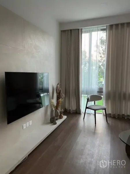 独立式住宅 出租在Saphan Sung, Bangkok - 电视特色墙配悬浮台面，高窗与单人椅。