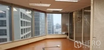 Office Space for rent in Bang Rak, Bangkok - Corner office with large panoramic windows, wood floors, and city skyline views in Silom.