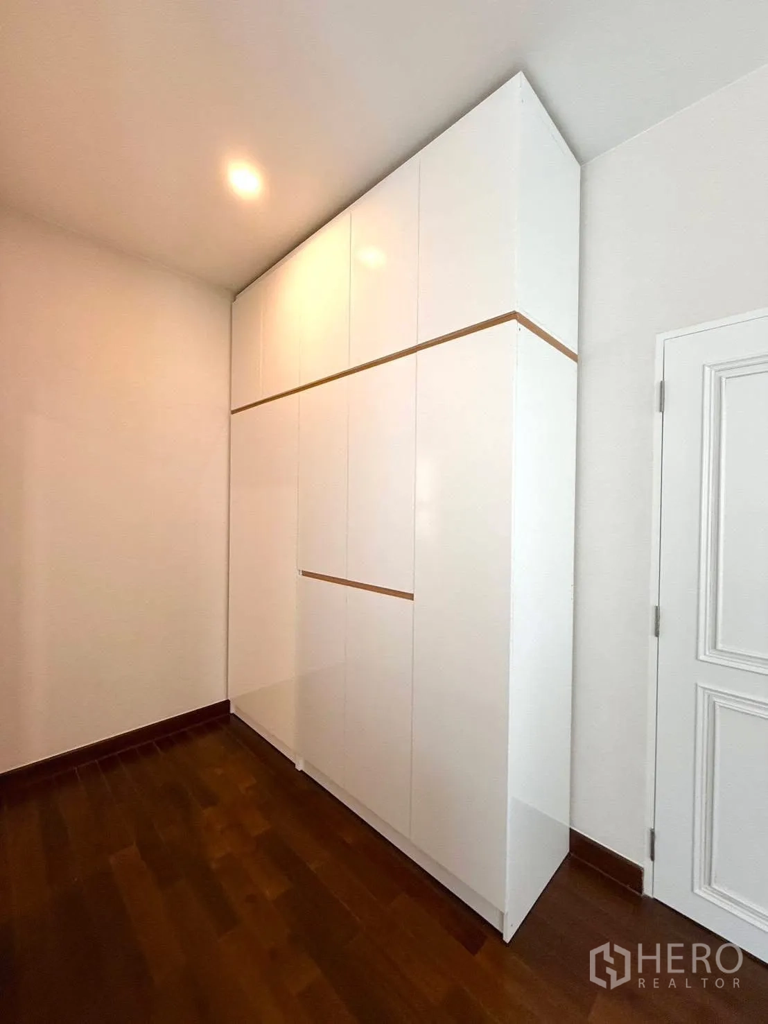 Detached House for rent or sale in Wang Thonglang, Bangkok - Tall white built-in wardrobe in a room with wooden flooring.