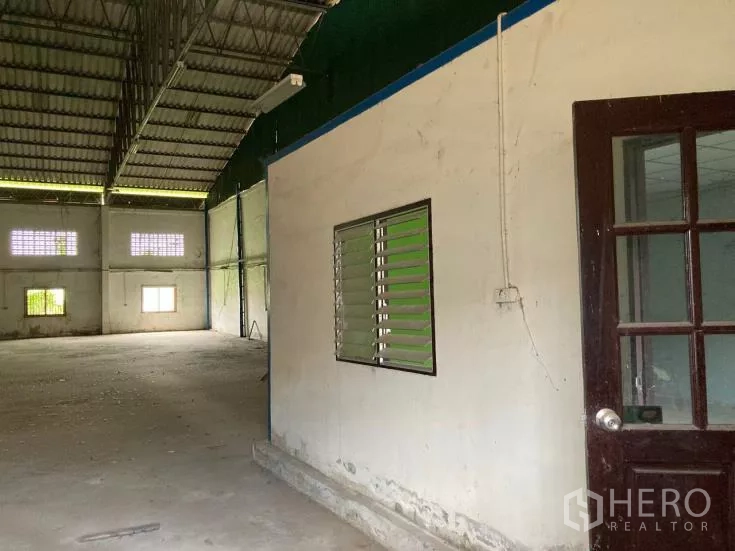Factory for rent in Bang Phli, Samut Prakan - Internal office room with louvered window beside an open production area and high roof.