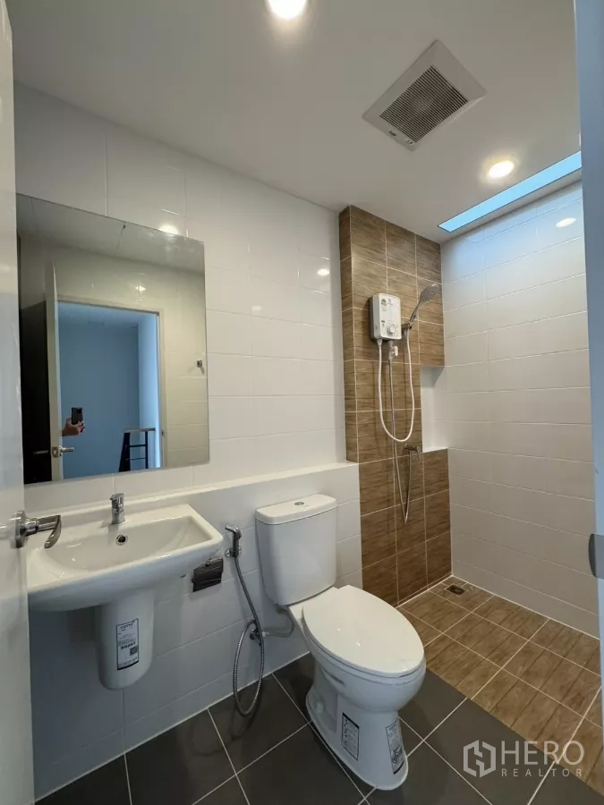 Townhouse for rent in Bang Phli, Samut Prakan - Modern bathroom with walk-in shower, water heater and white wall tiles.