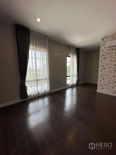 独立式住宅 出售在Prawet, Bangkok - 宽敞房间，木地板、落地窗与轻纱窗帘。