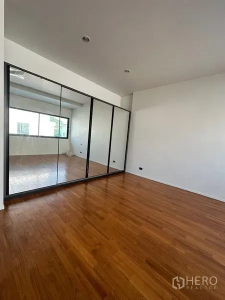 บ้าน ให้เช่าในWatthana, Bangkok - ห้องนอนพร้อมตู้เสื้อผ้าบานกระจกเต็มสูงและพื้นไม้ขัดเงา