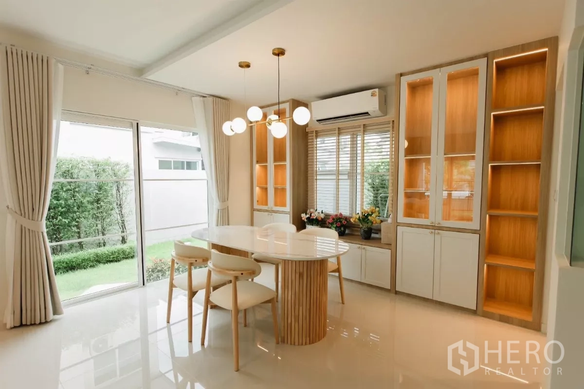 独立式住宅 出租或出售在Bang Phli, Samut Prakan - 餐厅配吊灯、内置展示柜并可观花园景观。
