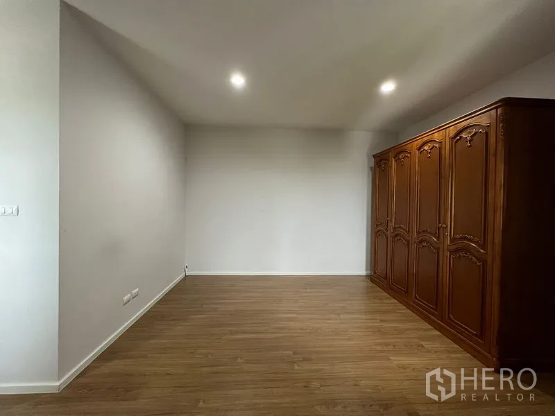 บ้าน ให้เช่าในSaphan Sung, Bangkok - อีกมุมของห้องนอนขนาดใหญ่พร้อมตู้ไม้แกะลายและไฟดาวน์ไลท์