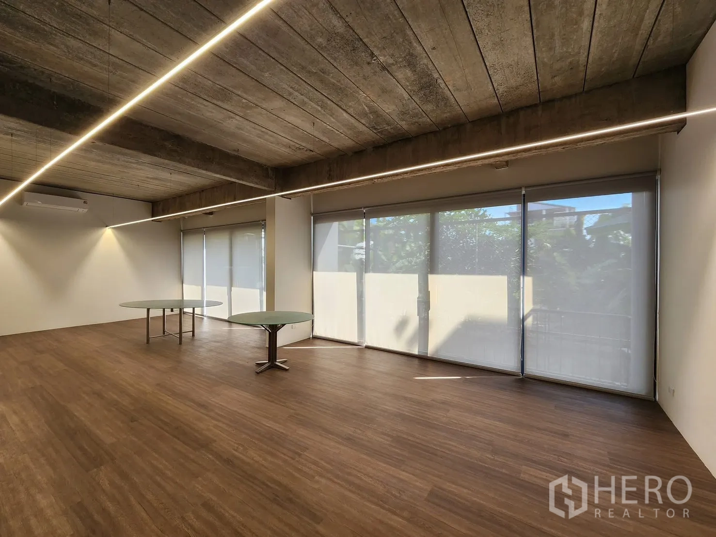 家庭办公室 for rent in Chatuchak, Bangkok - 开放会议区，配两张圆桌和带卷帘的落地窗。