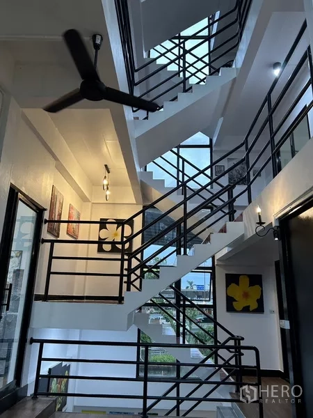 带办公室的家 出租或出售在Phra Khanong, Bangkok - 开放式楼梯间，黑色金属栏杆、吊扇，自然采光充足。