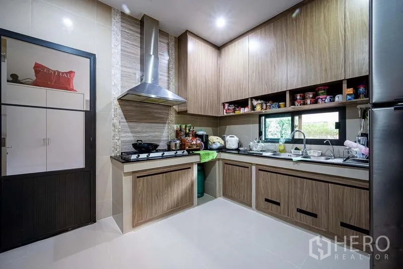 Detached House for sale in Prawet, Bangkok - Fitted kitchen with range hood, L-shaped cabinets and window.