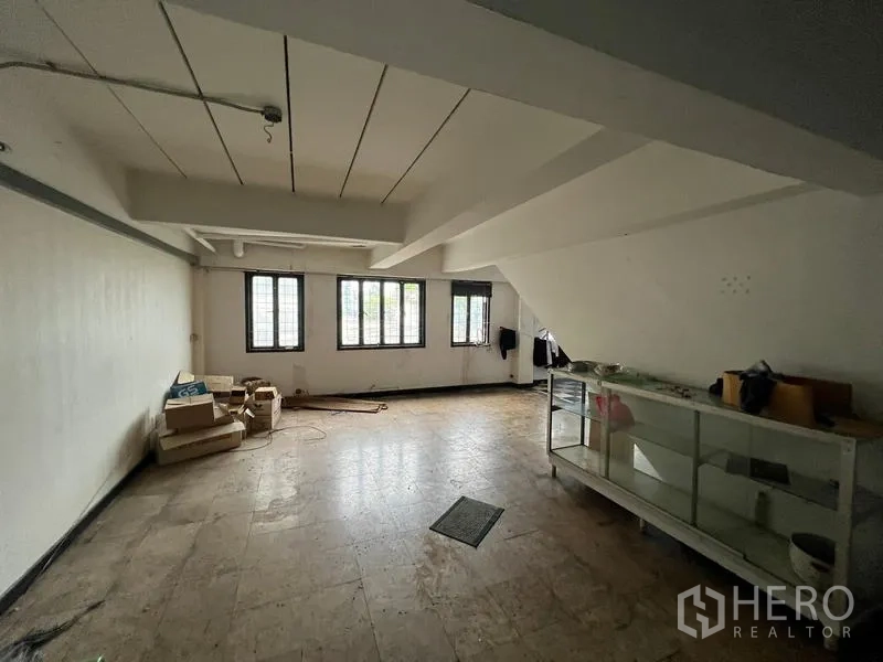 店屋 出租在Phra Khanong, Bangkok - 楼上房间，白墙、多扇窗与展示柜。