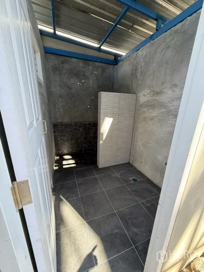 คลังสินค้า ให้เช่าในLam Luk Ka, Pathum Thani - อีกมุมของห้องน้ำปูกระเบื้อง มีผนังกั้นและพื้นกระเบื้องสีเทา