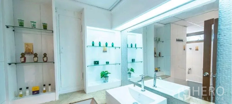 Condominium for rent in Watthana, Bangkok - Bright vanity area with backlit mirror and glass shelving.