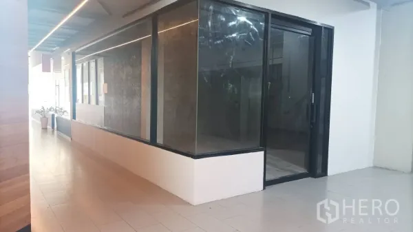 零售空间 出租 - 设有线性灯的长走廊，对面为大面积展示橱窗。