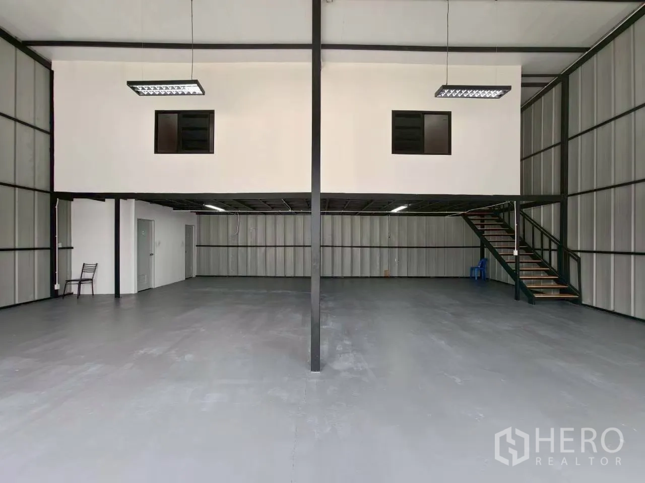 Warehouse for rent in Suan Luang, Bangkok - Symmetrical view of the warehouse showing central steel column and mezzanine office above the work area.