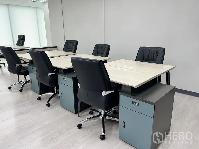 Office Space for rent in Sathon, Bangkok - Workstations with mobile pedestals and black chairs on laminate flooring.