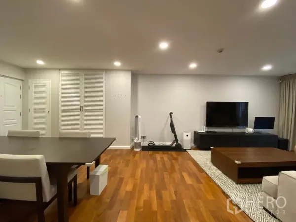 คอนโด ให้เช่าหรือขายในWatthana, Bangkok - ผนังทีวีจอแบนพร้อมตู้คอนโซล ถัดจากพื้นที่รับประทานอาหาร บนพื้นไม้โทนอุ่น