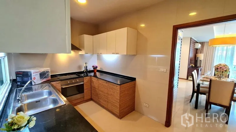 อพาร์ทเมนท์ ให้เช่าในKhlong Toei, Bangkok - มุมมองจากครัวไปยังโซนทานอาหาร ตู้เก็บของเยอะและไฟใต้ตู้