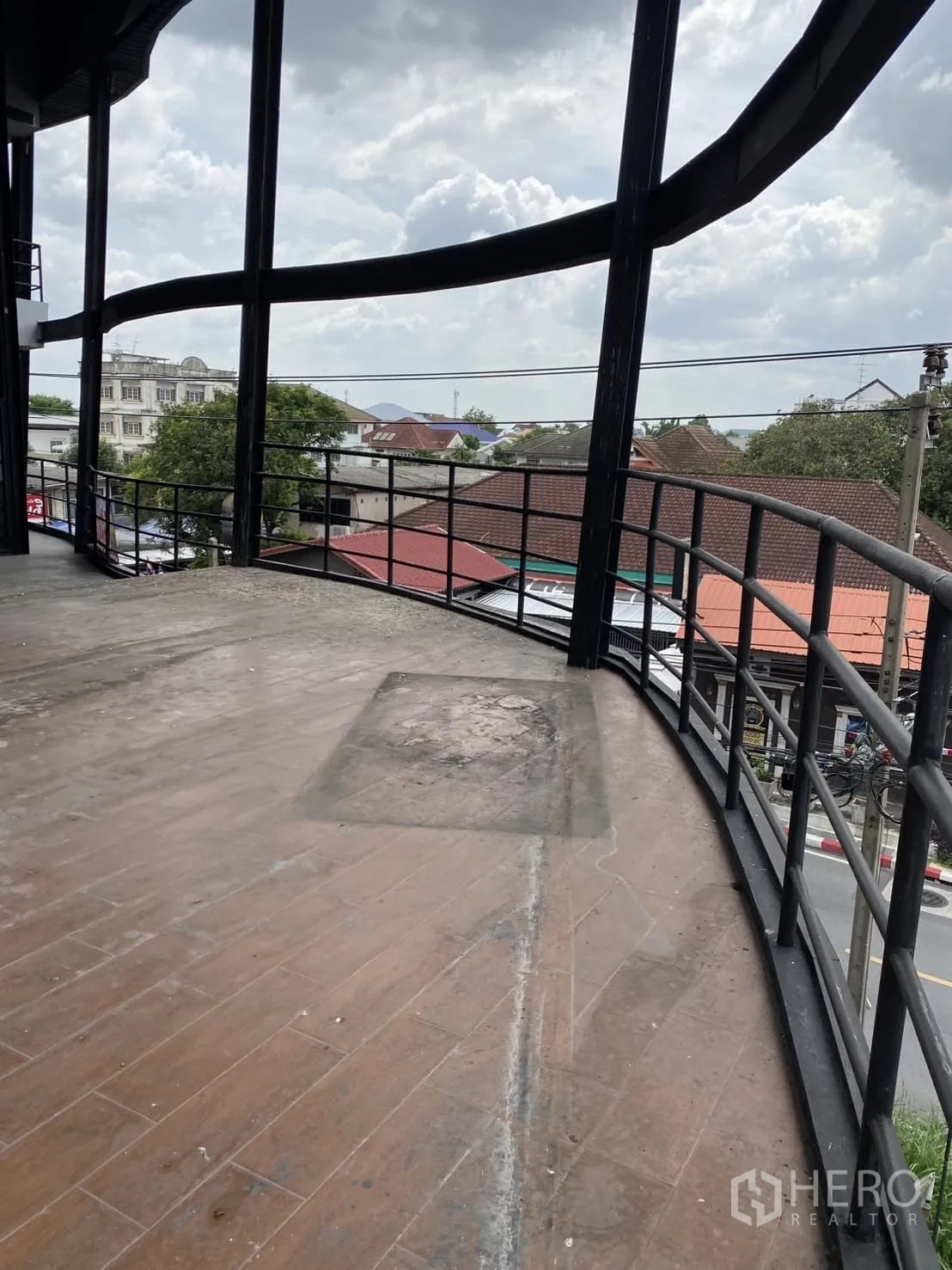 展厅 出租在Lat Phrao, Bangkok - 宽敞弧形露台，金属栏杆，可俯瞰周边社区景致。