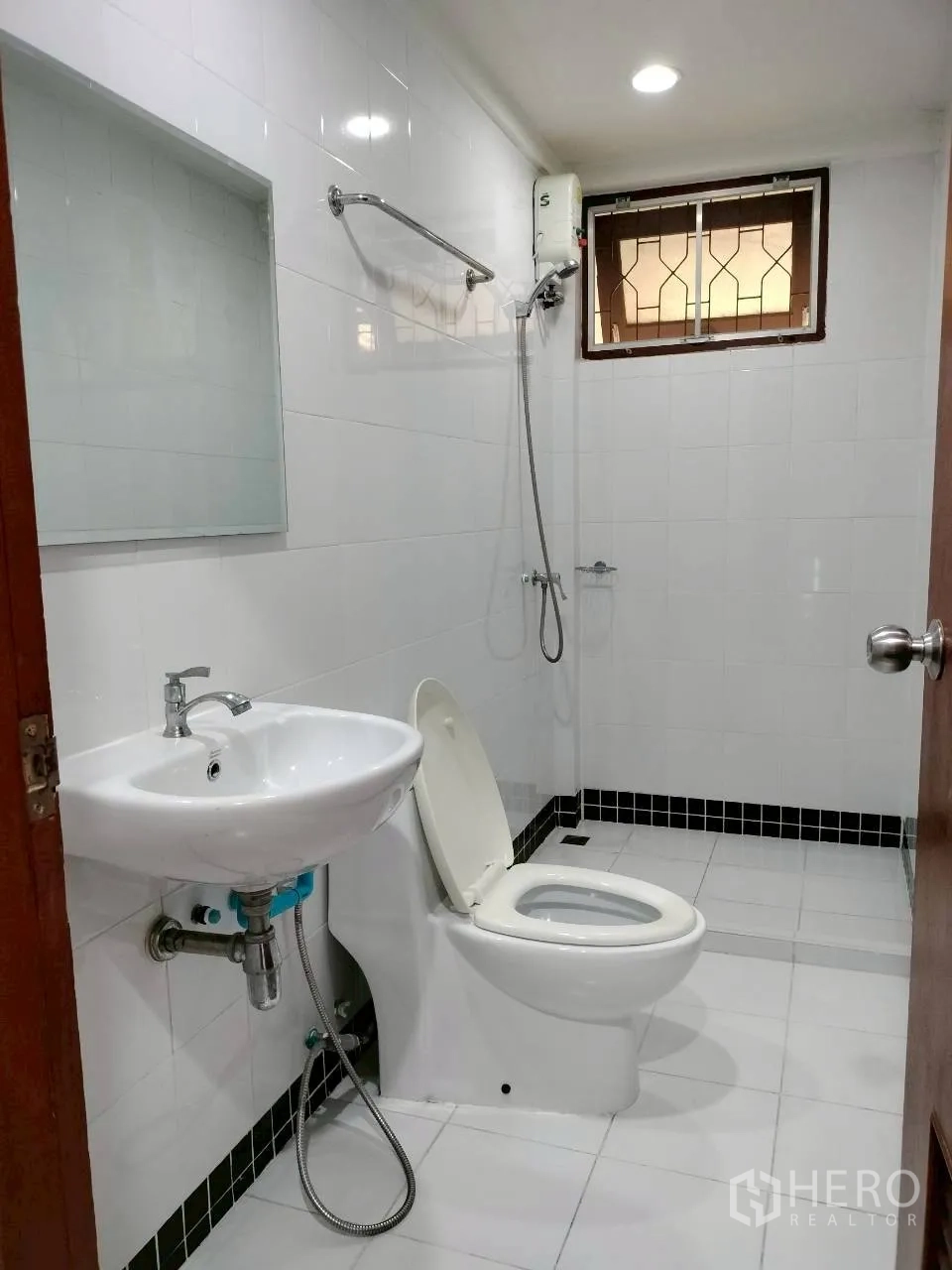 Home Office for rent in Watthana, Bangkok - Bathroom with shower unit, toilet, and wall mirror.