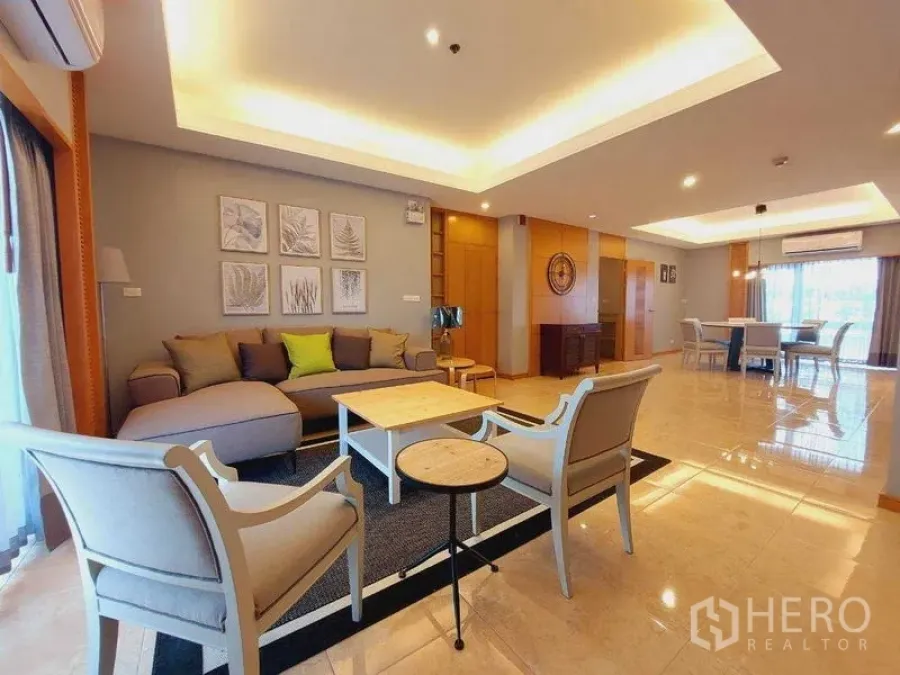 房间 出租 - 开放式客餐厅，天花灯带，沙发组合、扶手椅、茶几与大窗户。