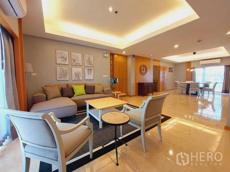 房间 出租 - 开放式客餐厅，天花灯带，沙发组合、扶手椅、茶几与大窗户。