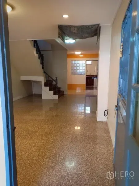 ทาวน์เฮาส์ ให้เช่าในPhra Khanong, Bangkok - พื้นที่นั่งเล่นแบบเปิดโล่ง พื้นหินขัด ไฟดาวน์ไลท์ และบันไดขึ้นชั้นบน